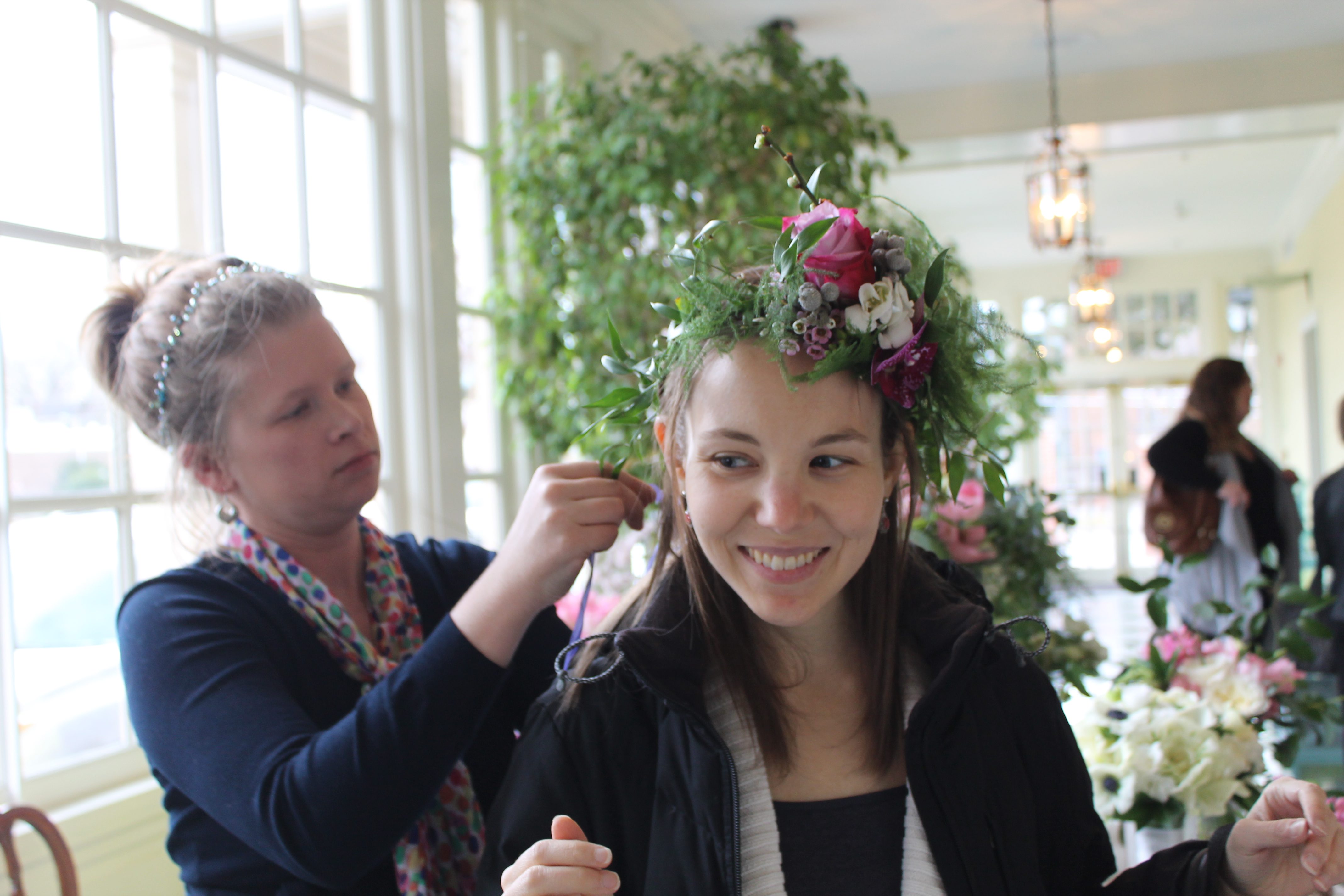 Purple Puddle’s Jennifer Wood places a flower crown on Julia Ward. Photo by Laura Zolman Kirk