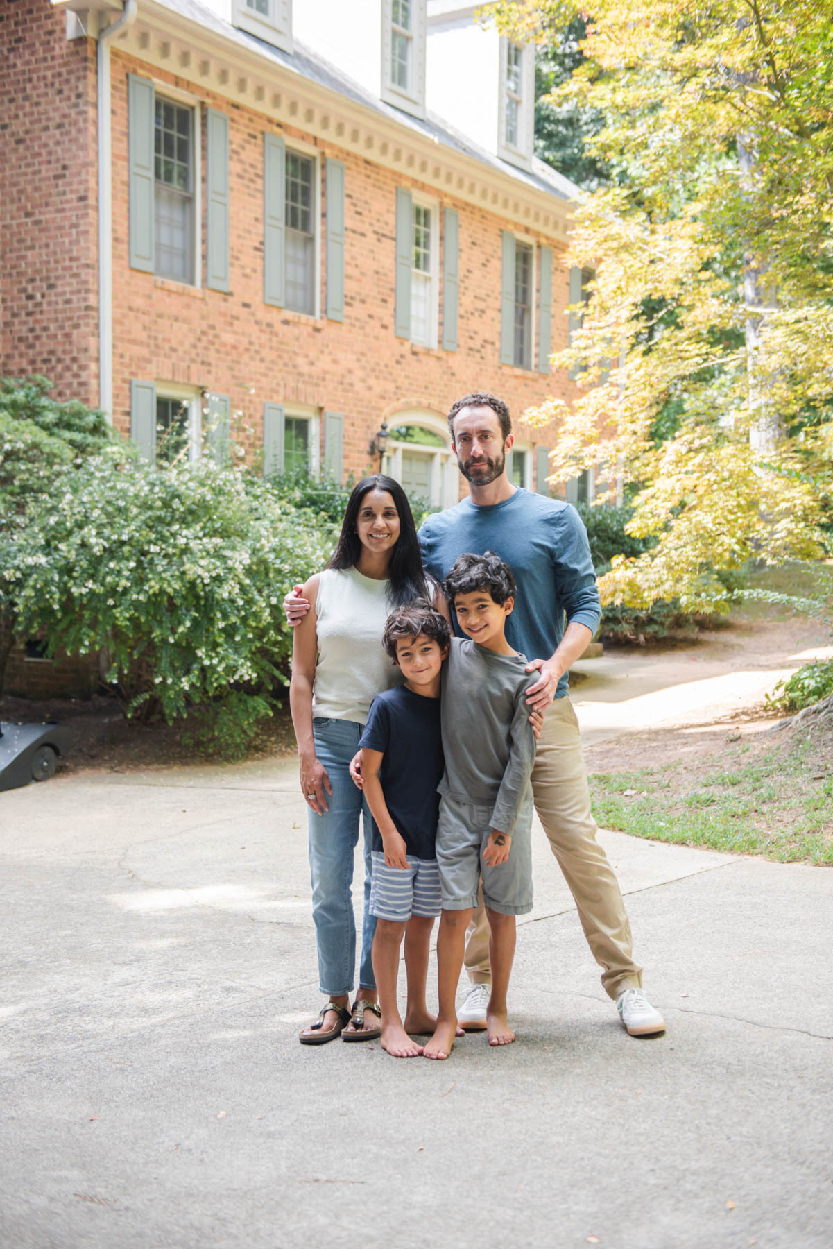 Renu and Sam Mathias with their two children, Taj, 8, and Kirin, 7, in front of their home. 