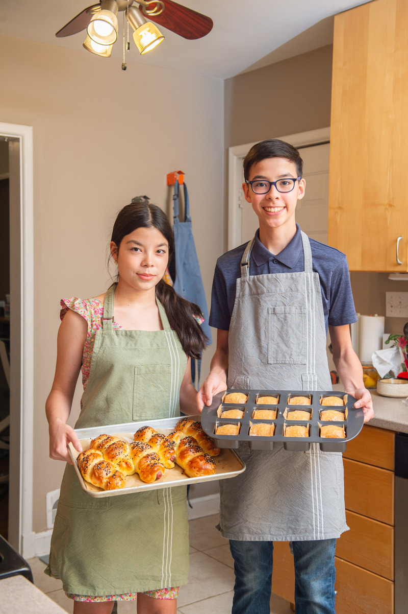 Twin bakers hold up handmade items