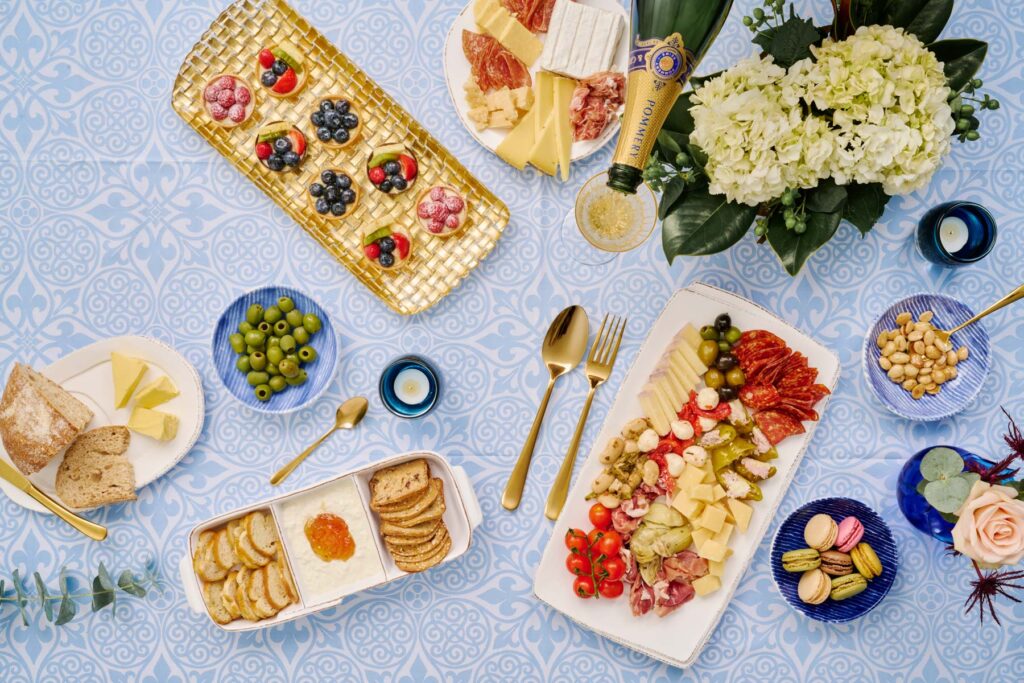 This stunning Wegmans spread has
everything you need to impress – from fresh sourdough bread and creamy French butter to elegant tarts and macarons, fresh florals and a pop of Champagne. Enjoy Danny’s Favorite Collection – the award-winning Professor’s Brie, Baby Bleu
and Triple Crème – alongside Danny’s Favorite Olive Mix and
Marcona almonds. 

Our table is set with a Lastra White Dinner Plate, Settimocielo
Serving Set, Settimocielo Spreader, Natalia Gold Champagne
Glass, Hibiscus Glass Cobalt Bud Vase, Damascus Tablecloth,
Melamine Lastra White Three-Part Server, Lastra Oval Tray,
Lastra White Rectangular Platter, Rufalo Glass Gold Basketweave
Large Rectangular Tray, Santorini Stripe Condiment Bowls and
spoons from a Settimocielo Five-Piece Place Setting – all from
Hillsborough-based Italian dinnerware and decor company Vietri.