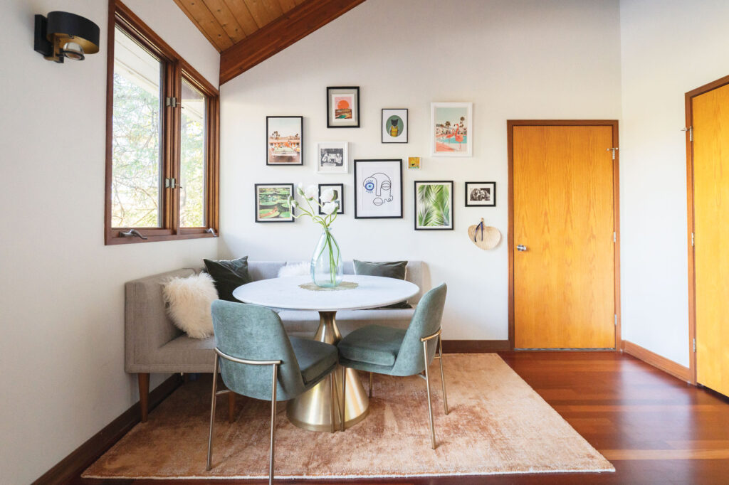 Interior designer Ana Tavares's breakfast nook features a plush blue sofa with pastel faux pillows and eclectic art on the walls.