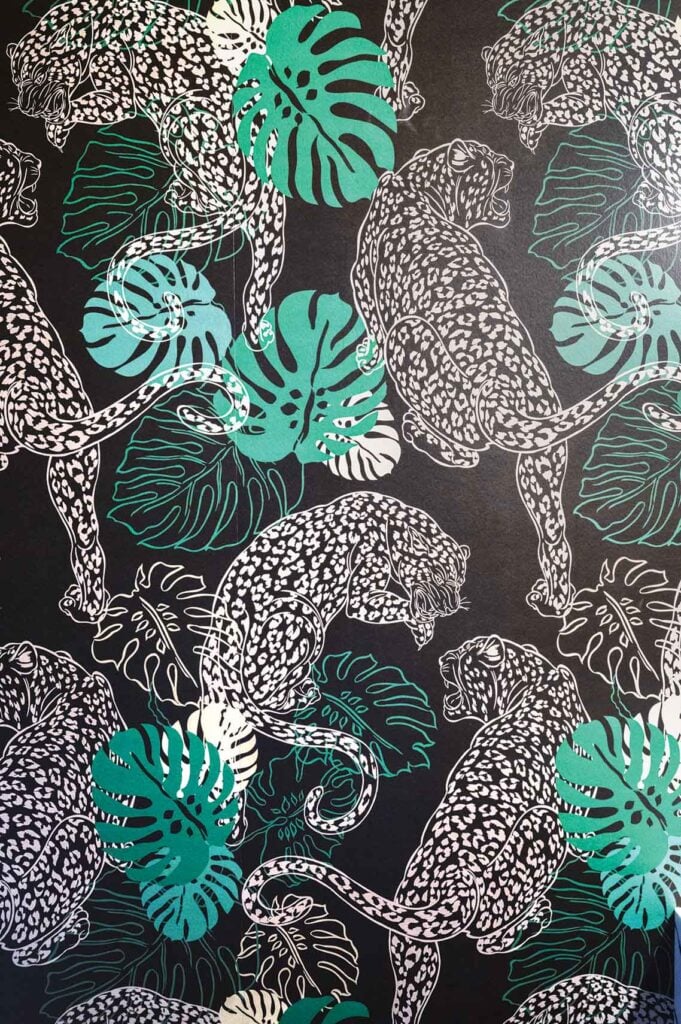 Interior designer Ana Tavares's half-bath features leopard-patterned wallpaper.