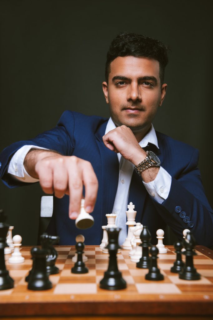 Priyav Chandna of MyChessTutor moving a chess piece during a match setup.