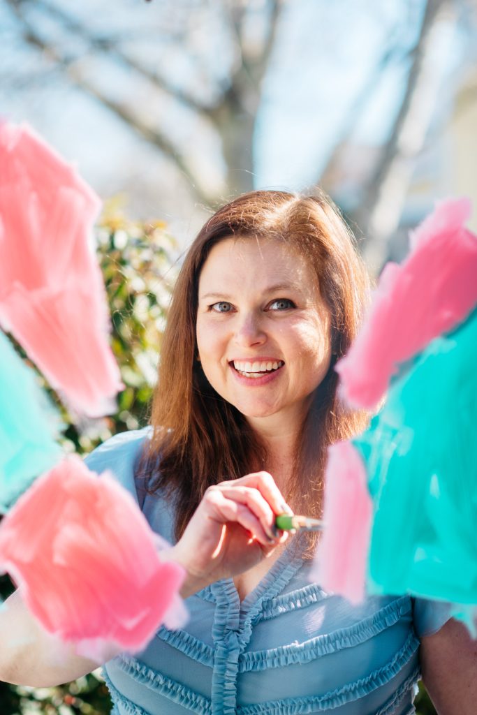 Artist Meghan Rosenthal painting on a sheet of plexiglass during a portrait.