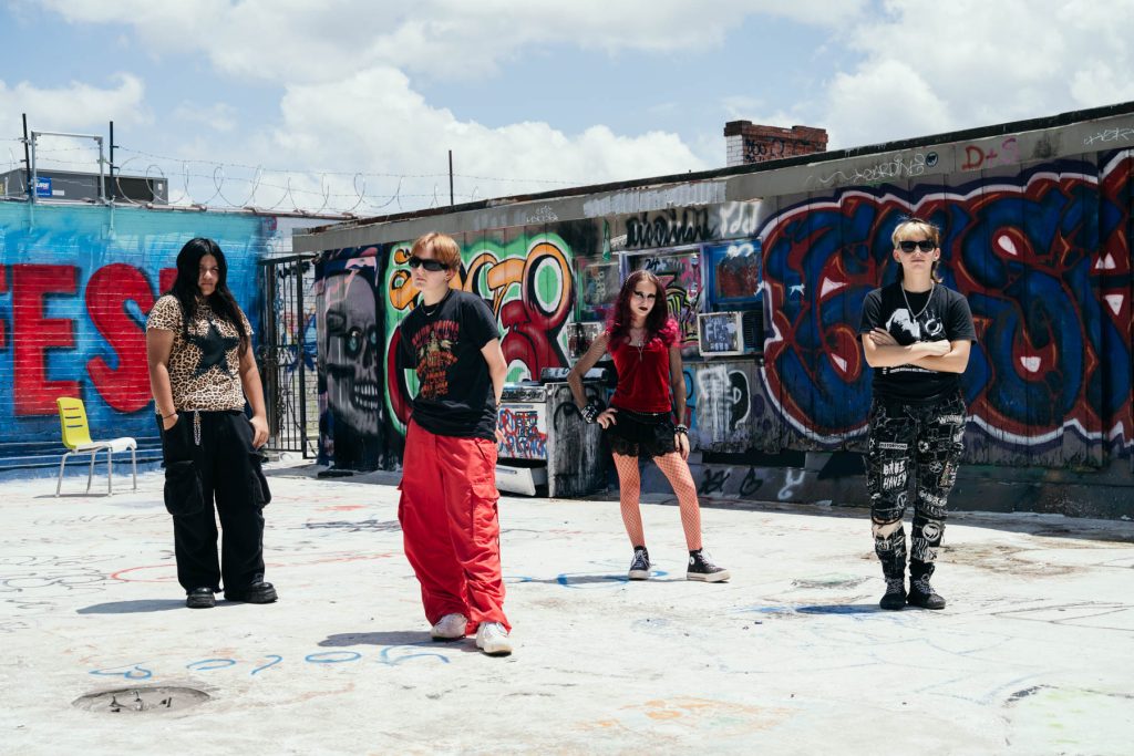 Members of Chapel Hill band Chiroptera standing on a graffiti-covered rooftop.