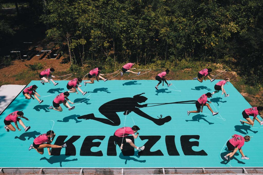 Bouncing Bulldogs jump rope team jumping on a mat with “Kenzie” written across it to honor teammate Kenzie Ruston.
