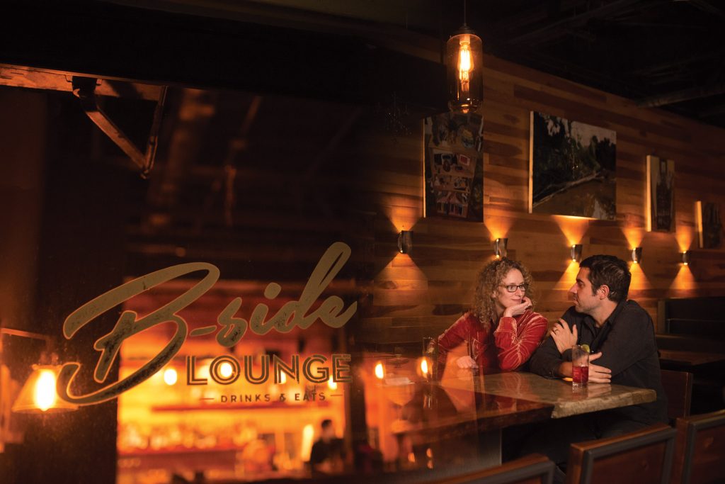 Couple sitting at a table inside B-Side Lounge with a double exposure reflection.