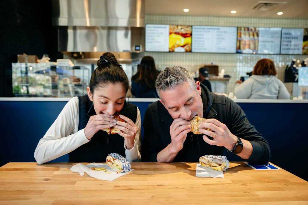 H&H Bagels Owners Amanda Klein and Michael Klein enjoy bagel sandwiches.