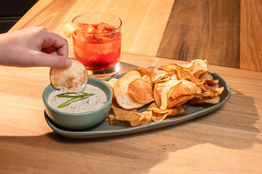 Little Gem cocktail beside chips and dip.